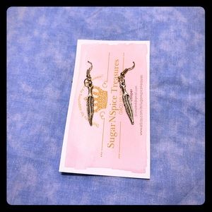 Silver toned feather dangle earrings